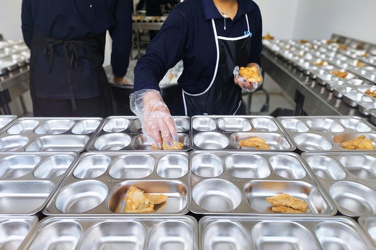 Portrait of officers at the Palmerah Nutrition Services Fulfillment Unit (SPPG) filling ompreng with flour fried tofu for the Free Meal Program (PMG) this morning, Monday (6/1/2025). 