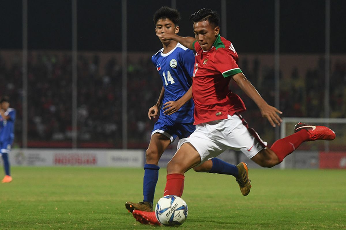 Pesepak bola Indonesia U-16 Mochamad Yudha Febrian (kanan) berusaha menendang bola dan dihalangi pesepak bola Filipina U-16 Florenz Carlos  (kiri) dalam laga penyisihan grup A Piala AFF U-16 di Gelora Delta Sidoarjo, Sidoarjo, Jawa Timur, Minggu (29/7/2018). Indonesia menang atas Filipina dengan skor 8-0.