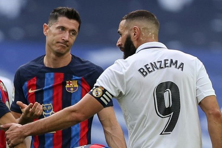 Robert Lewandowski (kiri) dan Karim Benzema (kanan) berbicara satu sama lain dalam laga Real Madrid vs Barcelona di Stadion Santiago Bernabeu, Spanyol, pada 16 Oktober 2022. Kini, Lewandowski dan Benzema bersaing di papan atas daftar top skor Liga Spanyol 2022-2023.