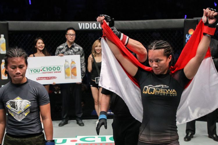 Petarung putri Indonesia, Priscilla Hertati, melakukan selebrasi setelah berhasil mengalahkan Angelie Sabanal pada pertandingan tarung bebas (MMA) One Championship kelas atomweight yang berlangsung di Stadion Istora, Senayan, Jakarta, Sabtu (17/11/2018) malam.