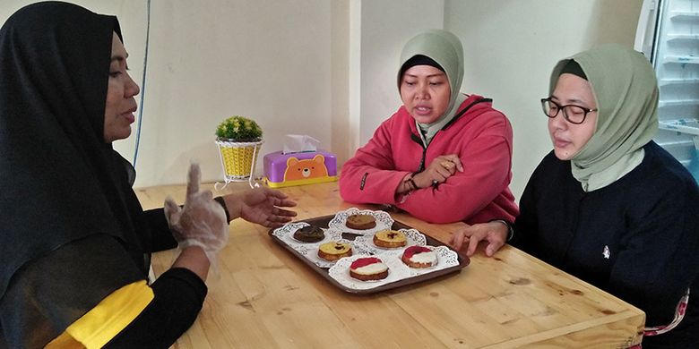 Nikmatus (kiri) saat berbincang dengan para konsumen terkait kue lumpur produksi tokonya di Gresik, Senin (29/10/2018).