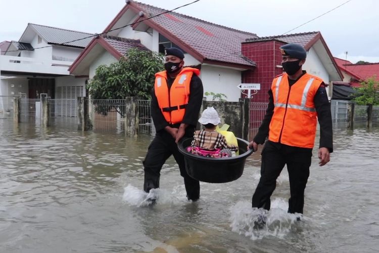 Polisi membantu mengevakuasi seorang Balita dari kediamannya di Desa Lampasie Engking, Aceh Besar yang terendam banjir. Hujan dengan intensitas tingi mengguyur sejak Jumat, dan menyebabkan empat Kecamatan di Kabupaten Aceh Besar dilanda banjir.