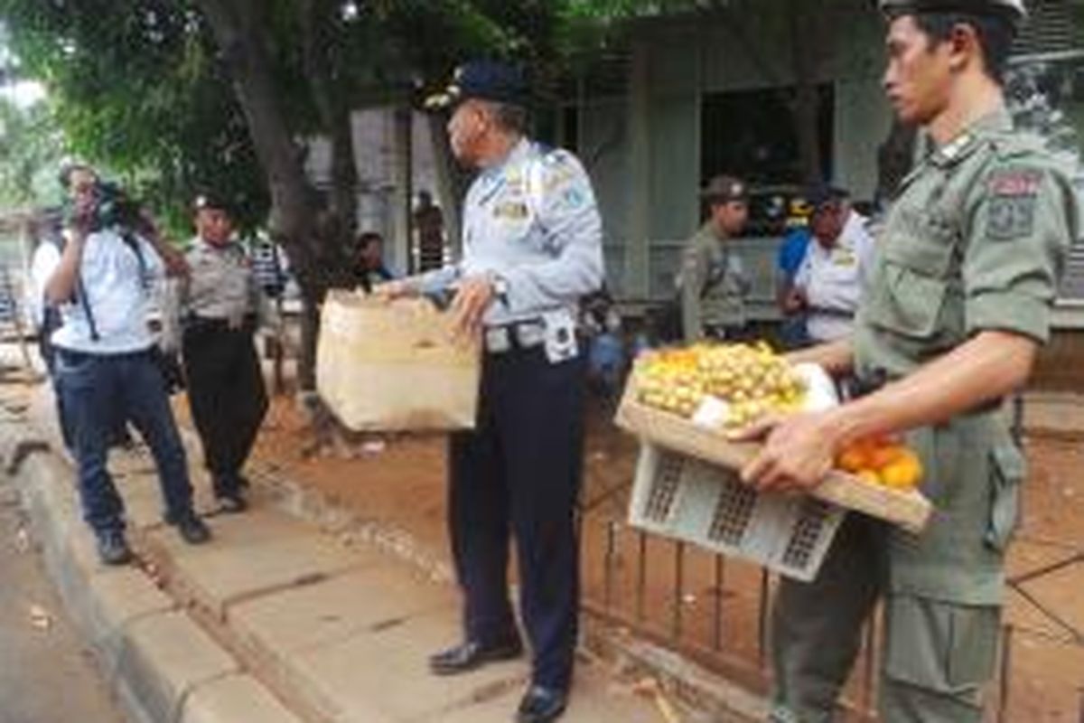 Satpol PP mengangkut kotak dagangan buah milik PKL di Kampung Rambutan, Jakarta Timur. Senin (2/11/2015)