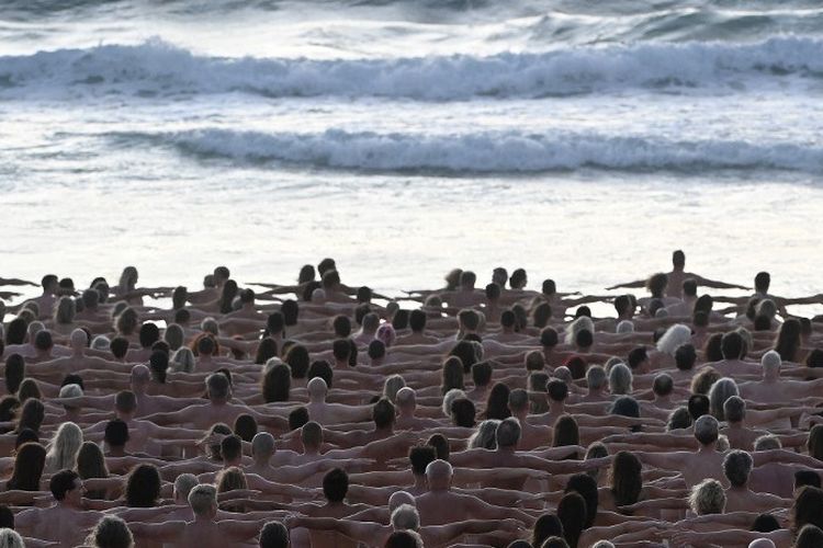 Para sukarelawan berpose telanjang saat matahari terbit di Pantai Bondi, Sydney, Australia, untuk fotografer seni AS Spencer Tunick, untuk meningkatkan kesadaran akan kanker kulit, pada 26 November 2022.