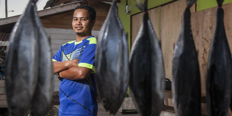 Sanedi (32) berpose saat di foto di depan kedai ikan miliknya di Jemengan, Bunguran Timur, Pulau Natuna, Selasa, 8 Oktober 2019. Sanedi berjualan ikan menggunakan sistem daring melalui sosial media Facebook sejak 2017. 