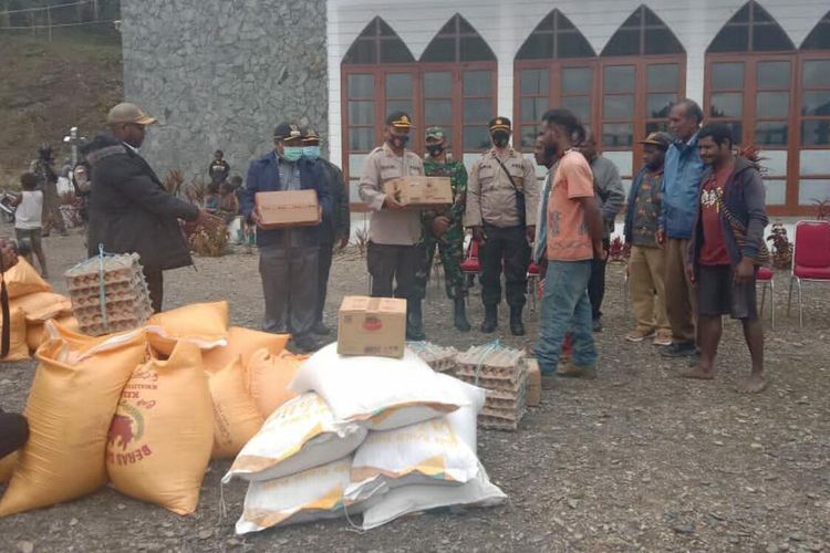 Bupati Intan Jaya Natalis Tabuni bersama Kapolres Intan Jaya I Wayan G Antara menyerahkan bantuan bahan pokok ke pengungsian warga di Komplek Pastoean Gereja Katolik Santo Mikael, Distrik Sugapa, Intan Jaya, Papua, Kamis (12/2/2021)