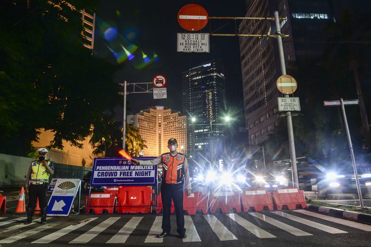 Petugas gabungan menutup akses jalan menuju Bundaran Hotel Indonesia dari Jalan Imam Bonjol, Jakarta, Jumat (31/12/2021). Polda Metro Jaya memberlakukan pengendalian mobilitas Crowd Free Night (malam bebas keramaian) pada malam tahun baru 2022 yang berlangsung mulai pukul 22.00 - 04.00 WIB.