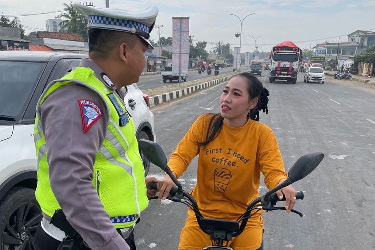 Petugas Direktorat Lalulintas Polda Banten saat memberikan himbauan kepada pengendara sepedah listrik di Jalan Raya Syekh Nawawi Al Bantani, Kota Serang pada hari pertama Operasi Patuh Maung 2023.