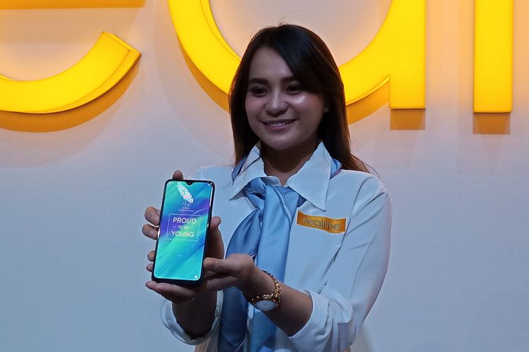 Ilustrasi Realme 3 dalam genggaman. Realme 3 tampak tidak terlalu besar dan tidak terlalu kecil dengan bezel yang terlihat tipis.