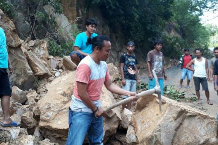 Sejumlah masyarakat berupaya membuka jalan yang ditutupi material batu dengan alat seadanya. Hingga pagi ini jalur selatan yang menghubungkan Provinsi Gorontalo dan Sulawesi Utara masih tertutup