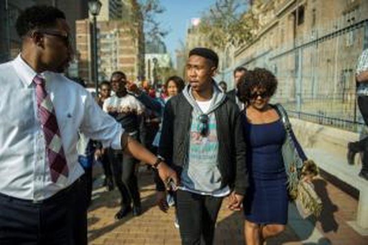 Cucu Nelson Mandela (tengah) meninggalkan pengadilan di Johannesburg, Selasa (25/8/2015), setelah hakim mengabulkan permohonan bebas bersyaratnya. Dia dituduh memperkosa seorang gadis di bawah umur awal Agustus lalu.