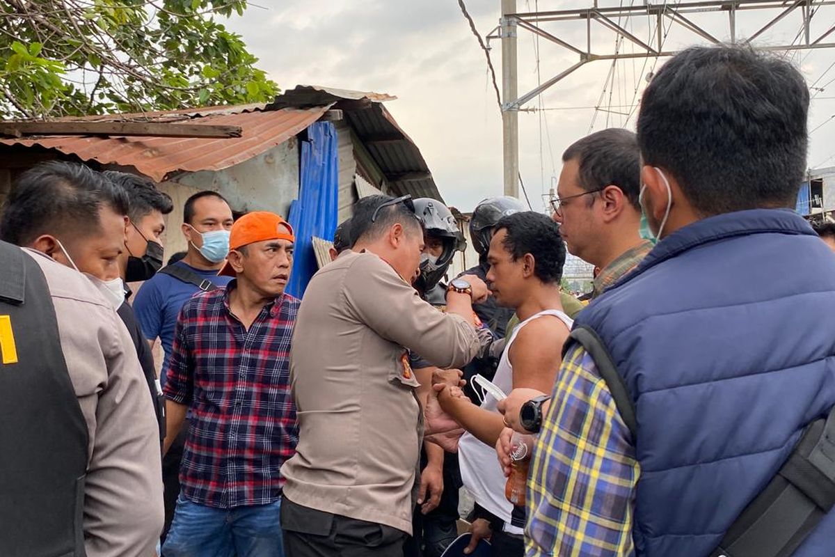 Seorang pria memberontak untuk bertemu istrinya saat digerebek di Kampung Bahari, Tanjung Priok, Jakarta Utara pada Rabu (30/11/2022). Dia meminta dipertemukan dengan sang istri, sebelum digiring ke kantor polisi. 