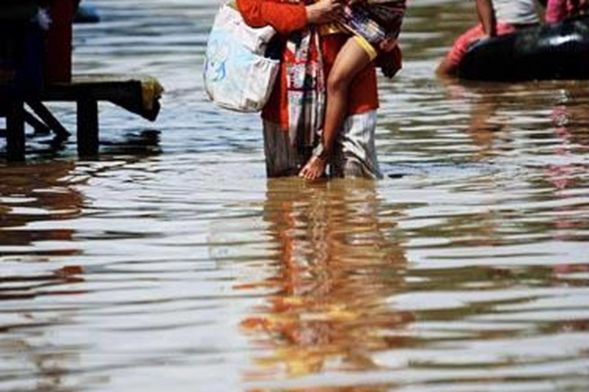 Warga menyeberangi genangan banjir yang merendam Jalan Anggadiredja, Baleendah, Kabupaten  Bandung, Jawa Barat, akibat luapan Sungai Citarum, Rabu (27/4). Ribuan rumah warga di Kecamatan Dayeuhkolot dan Baleendah terendam banjir setelah sehari sebelumnya terjadi hujan yang cukup deras di  daerah hulu  sungai tersebut.
