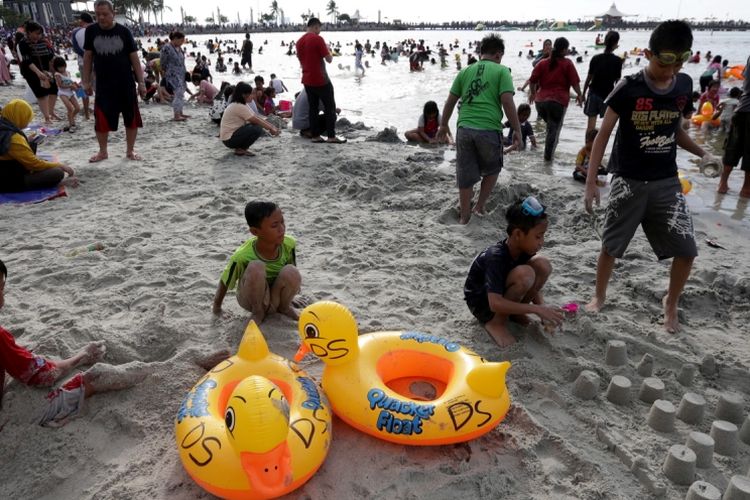 Pengunjung memanfaatkan liburan mengunjungi pantai di kawasan Taman Impian Jaya Ancol, Jakarta, Selasa (27/6/2017). Sejumlah lokasi wisata di Jakarta padat pengunjung pada libur lebaran. 