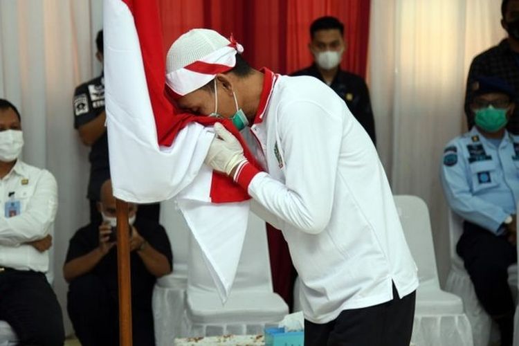 Narapidana tindak pidana terorisme mencium bendera Merah Putih usai mengucap ikrar setia kepada NKRI di Aula Sahardjo, Lapas Narkotika Kelas IIA Gunung Sindur, Kabupaten Bogor, Jawa Barat, Kamis (15/04).