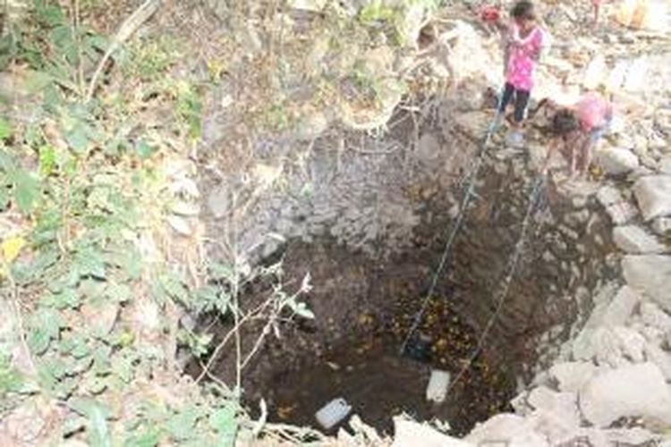 Anak-anak Desa Haumeni, Kecamatan Bikomi Utara, Kabupaten Timor Tengah Utara (TTU), Nusa Tenggara Timur, sedang mengambil air dari dalam kubangan air (Oe’Apot) yang kotor. Air itu digunakan warga untuk masak, minum. cuci dan mandi, Sabtu (20/9/2014) 