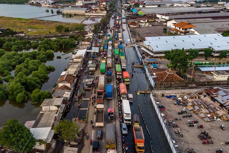 Kendaraan bermotor menembus jalan raya pantura Demak KM 8 ruas Demak-Semarang yang terendam limpasan air laut ke daratan (rob) di Demak, Jawa Tengah, Rabu (13/5/2020). Banjir rob yang melimpas ke jalur utama pantura Demak setinggi 15-40 sentimeter itu menyebabkan kemacetan lalu lintas sepanjang sekitar 7,5 kilometer dari Kabupaten Demak menuju Kota Semarang dan sekitar 1 kilometer dari Kota Semarang menuju Kabupaten Demak.