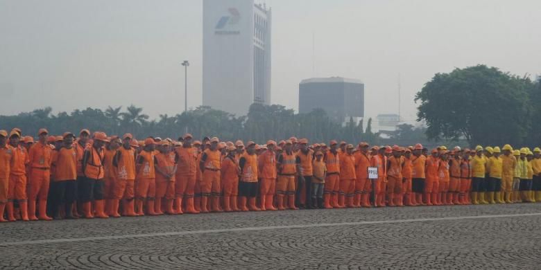 Pasukan oranye dari Dinas Kebersihan DKI mengikuti apel saber pungli di lapanhan Monas, Kamis (24/11/2016). 
