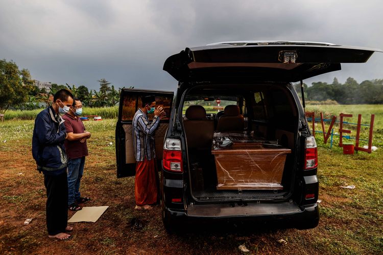 Warga melakukan shalat jenazah di dekat mobil ambulans berisi jenazah yang akan dimakamkan dengan protokol Covid-19 di Tempat Pemakaman Umum (TPU) Padurenan, Kota Bekasi, Jawa Barat, Rabu (18/6/2021). Satgas penanganan Covid-19 melaporkan kasus konfirmasi positif hingga Jumat (18/6/2021) bertambah 12.990 orang sehingga totalnya menjadi 1.963.266 kasus, sementara itu kasus meninggal akibat Covid-19 bertambah 290 jiwa sehingga totalnya telah menembus 54.043 jiwa.