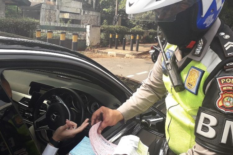 Seorang pengendara Marcedes Benz terkena tilang ganjil - genap jelang Asian Games di Tomang, Jakarta Barat pada Rabu (1/8/2018).