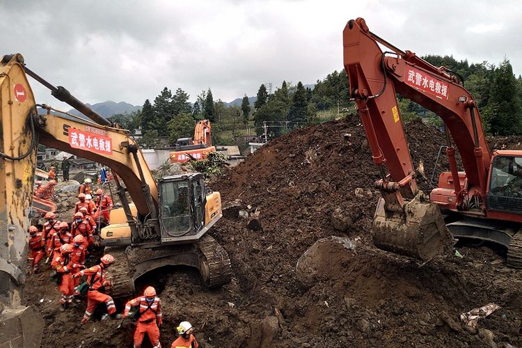 Petugas penyelamat dengan dibantu alat berat berusaha menemukan para korban yang terkubur tanah longsor di desa Shuicheng di Guizhou, Selasa (23/7/2019). Di negara tetangga China, Tajikistan, hujan telah menewaskan 13 orang.