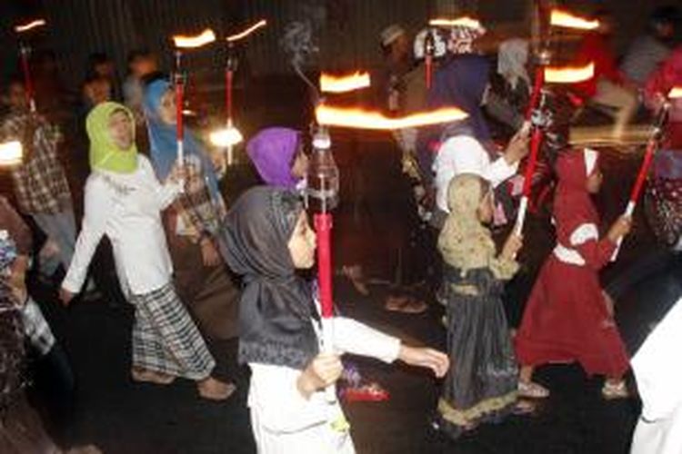 Anggota Majelis Ta'lim Miftahul Huda melakukan pawai obor pada malam takbiran di sekitar kawasan Glodok, Jakarta Pusat, Sabtu (18/8/2012). Malam takbiran mengawali perayaan Hari Raya Idul Fitri 1433 Hijriah yang jatuh pada Minggu,19 Agustus 2012.
