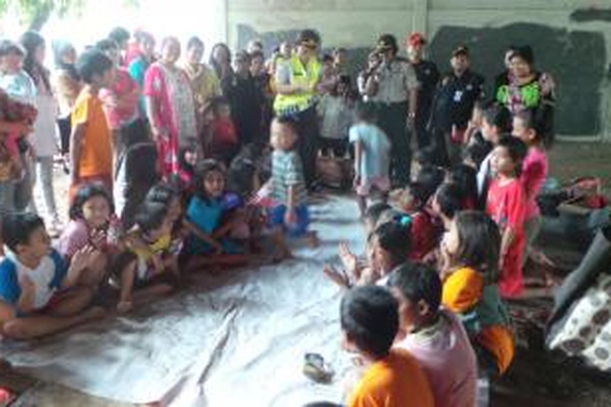 Polwan dari Polres Metro Jakarta Selatan menghibur dengan mengajak anak anak korban pengungsian banjir di Tebet, Jakarta Selatan bermain dan mengikuti lomba. Senin (20/1/2014).