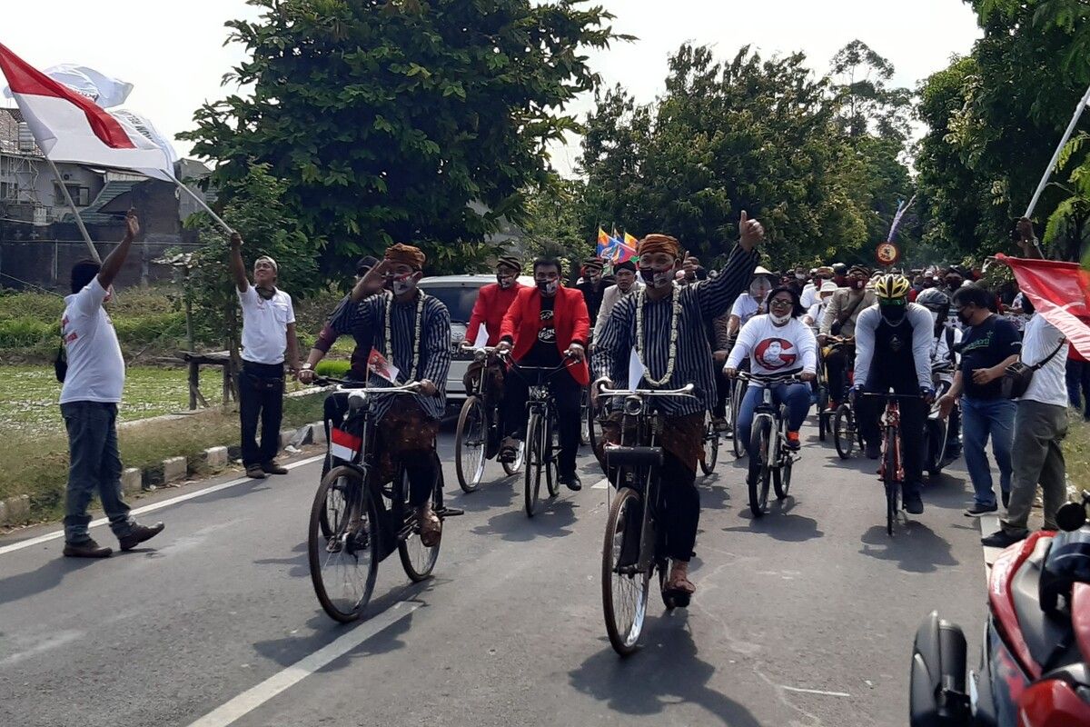 Paslon Wali Kota dan Wakil Wali Kota Solo, Gibran Rakabuming Raka dan Teguh Prakosa memakai pakaian adat Jawa dengan menaiki sepeda onthel menuju ke Kantor Komisi Pemilihan Umum (KPU) Solo, Jawa Tengah, Jumat (4/9/2020).