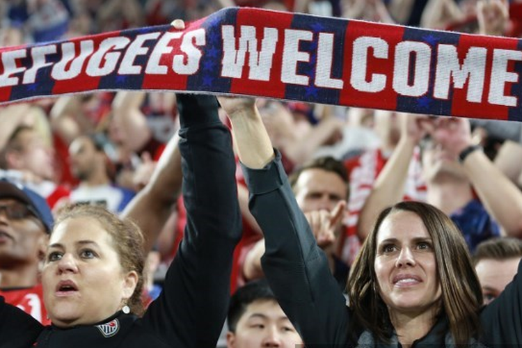 Suporter timnas Amerika Serikat membentangkan spanduk Refugees Welcome saat laga Piala Emas 2019 Grup D antara AS vs Guyana di Allianz Field in Saint Paul, Minnesota, 18 Juni 2019



