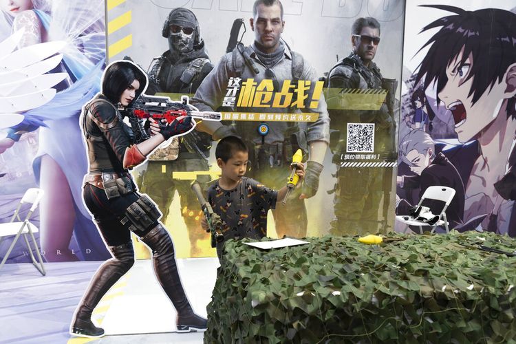 Seorang anak bermain dengan pistol mainan selama promosi untuk game online di Beijing pada Sabtu, 29 Agustus 2020. 