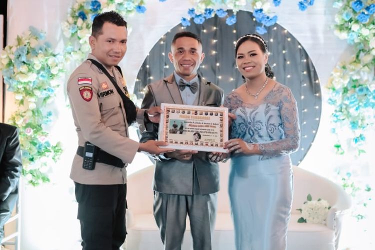 Brigadir Polisi Kepala (Bripka) M Virmon, saat memberikan piagam penghargaan kepada pengantin di Kelurahan Kefa Utara, Kabupaten Timor Tengah Utara, NTT