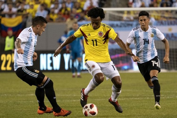 Pemain asal Kolombia, Guillermo Cuadrado, mengontrol bola di tengah penjagaan bek Argentina, Fabricio Bustos dan Angel Correa, saat pertandingan persahabatan, Rabu (12/9/2018). 