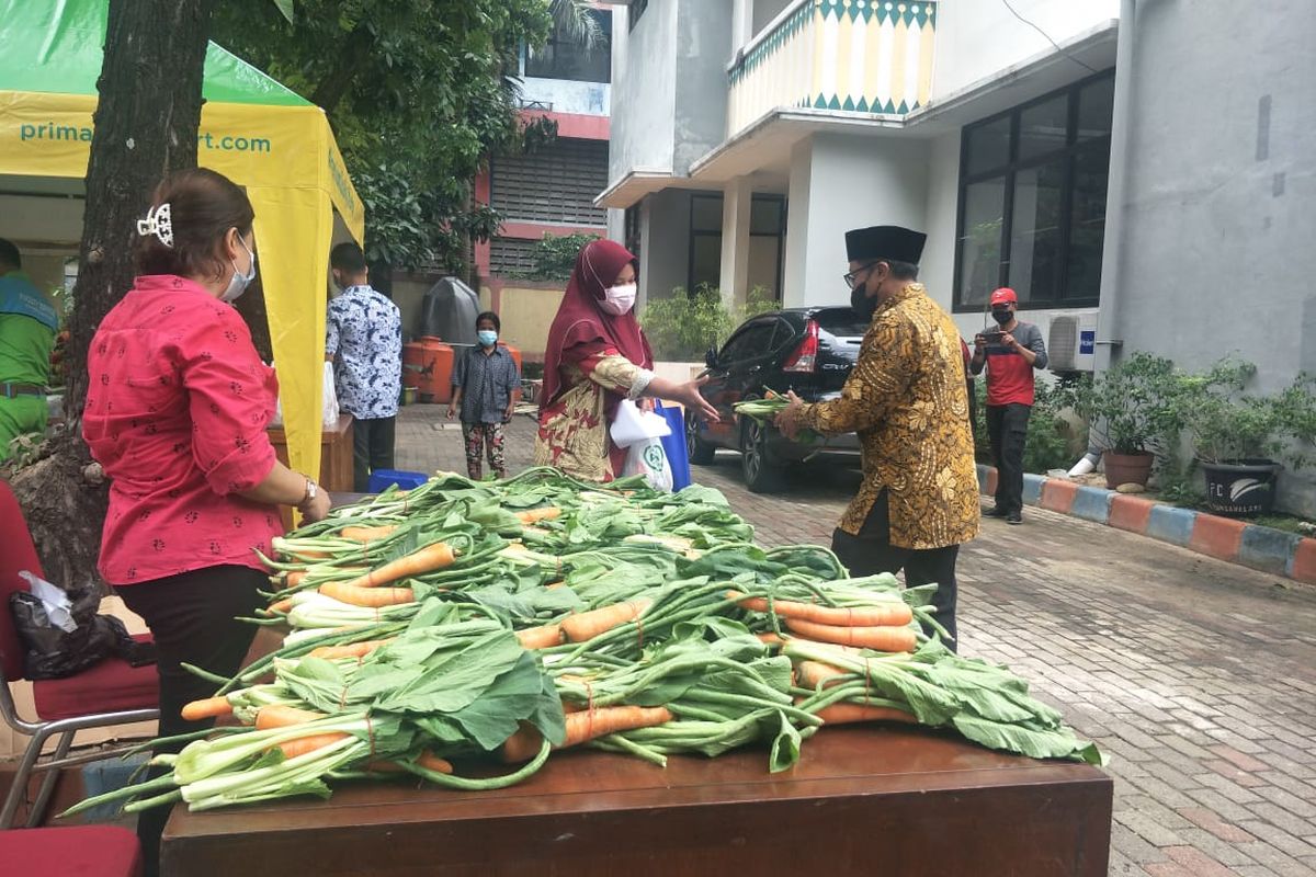 Lurah Ancol, Rusmin bagikan sayur dan sembako kepada warga yang menjalani vaksinasi Covid-19, di Kelurahan Ancol, Jakarta Utara, Kamis (17/6/2021).