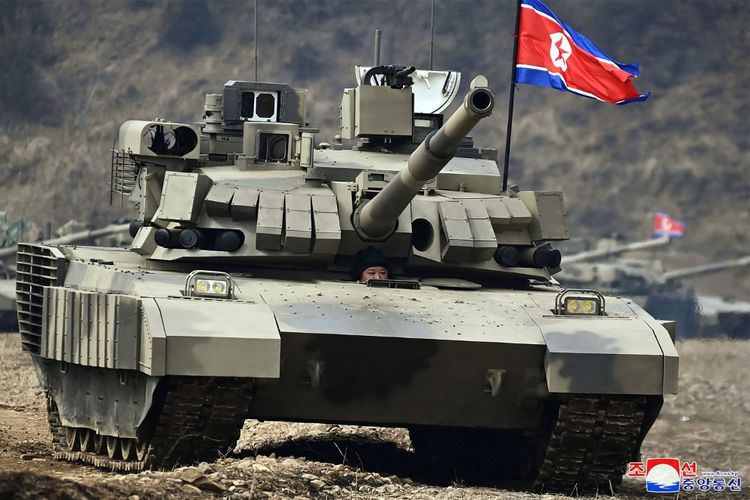 Gambar yang diambil pada 13 Maret 2024 dan dirilis oleh Kantor Berita Pusat Korea (KCNA) resmi Korea Utara pada 14 Maret 2024 ini menunjukkan pemimpin Korea Utara Kim Jong Un (tengah) dalam posisi pengemudi tank tempur utama baru.