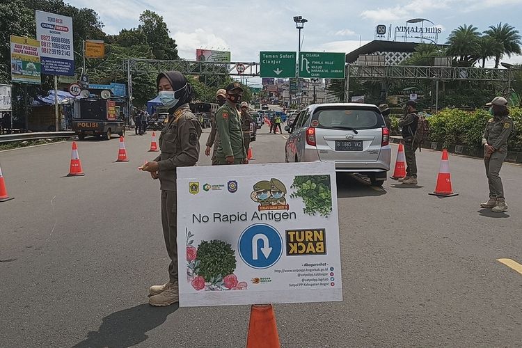 Sejumlah kendaraan terlihat diberhentikan saat hendak menuju kawasan Puncak Bogor di sekitar Simpang Gadog, Kecamatan Ciawi, Kabupaten Bogor, Jawa Barat, Jumat (12/2/2021).