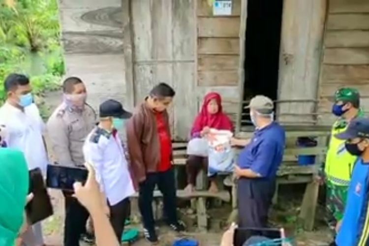 Foto capture dari video viral yang beredar di media sosial, seorang camat di Ogan Ilir memberikan beras bantuan dari Bupati Ogan Ilir dan mengatakan harus 2 periode ke penerimanya. 