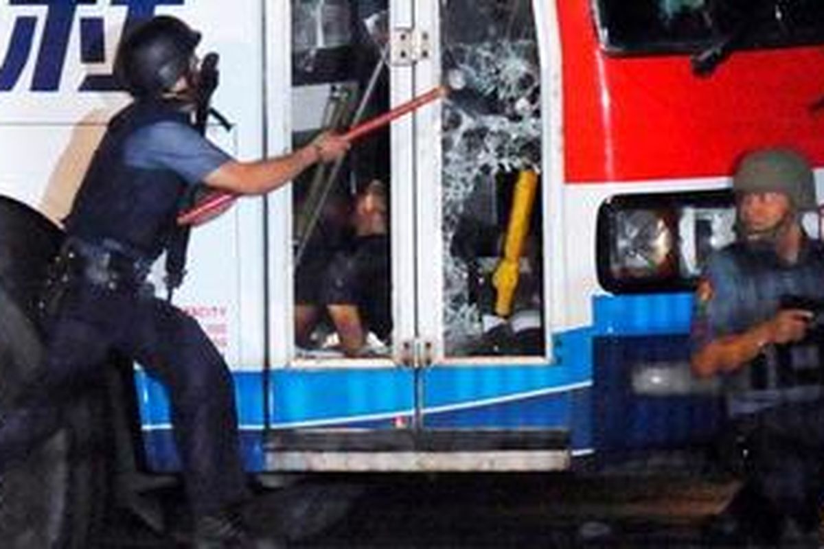 Polisi Filipina memecahkan kaca dekat pindi depan bus Hong Thai Travel mengangkut 20 orang wisatawan asal Hongkong yang dibajak pria bersenjata di Manila, Senin (23/8/2010).