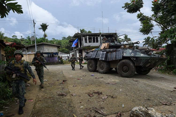 Militer Filipina berjalan di sebelah kendaraan lapis baja ringan V-300 mereka setelah menyerang militan pro-ISIS di Kota Marawi, Filipina, Jumat (2/6/2017). Pertempuran berdarah terjadi antara militer Filipina dengan pasukan Maute di Marawi dalam upaya menangkap pemimpin kelompok Abu Sayyaf, Isnilon Hapilon.