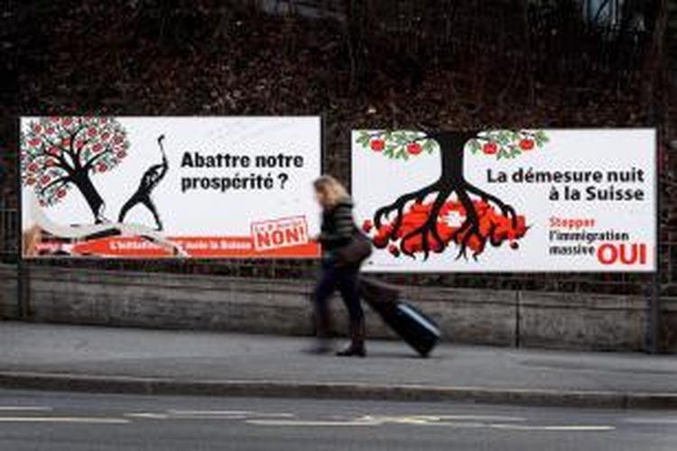 Warga kota Laussane, Swiss melintasi sebuah poster yang isinya adalah ajakan untuk membatasi jumlah imigran yang datang ke negeri tersebut. Dalam referendum yang digelar Minggu (9/2/2014), lebih dari separuh pemberi suara setuju adanya kuota imigran.