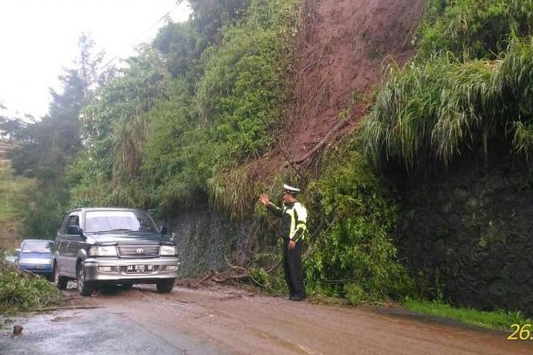 anggota Polres Wonosobo mengatur lali lintas di sekitar tanah longsor di dataran tinggi Dieng, Wonosobo, Jawa Tengah, Minggu (26/2/2017) sore.