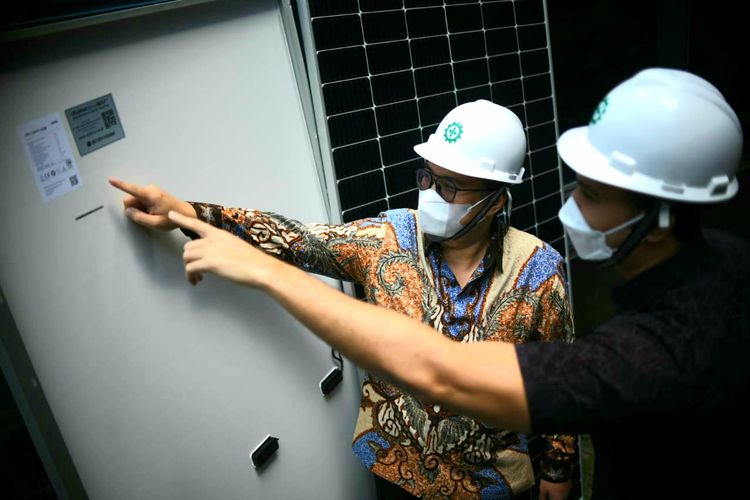 Managing Director Utomo SolaRUV, Anthony Utomo  (kiri) memperlihatan panel surya bersertifIkat SNI ke Ihsan Fadhlur Rahman, mitra outlet Juragan Atap Energi Surya, di Jakarta, Jumat (31/12/21).