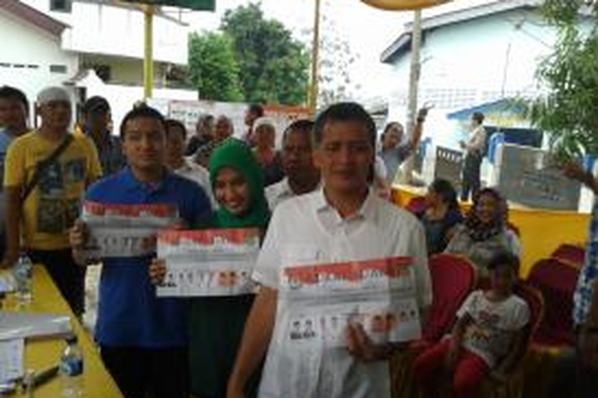 Calon Wali Kota Tangerang Abdul Syukur bersama istri, Fajrah Hayati dan seorang anaknya, saat akan menggunakan hak pilihnya di TPS 4, Kelurahan Pinang, Kecamatan Pinang, Kota Tangerang, Sabtu (31/8/2013)