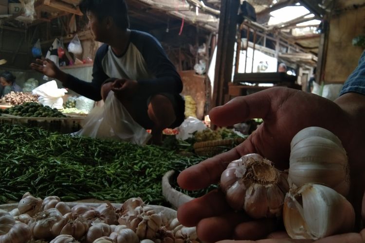 Seorang pembeli tengah memilah cabai dan bawang putih di salah satu pasar tradisional di Karawang.