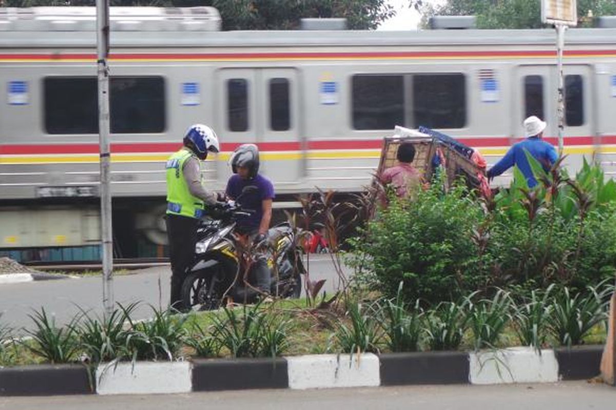 Pengendara sepeda motor diperiksa petugas polisi dalam Operasi Zebra di depan pintu perlintasan kereta IISIP, arah Depok, diJalan Raya Lenteng Agung, Jakarta Selatan, Kamis (4/12/2014).