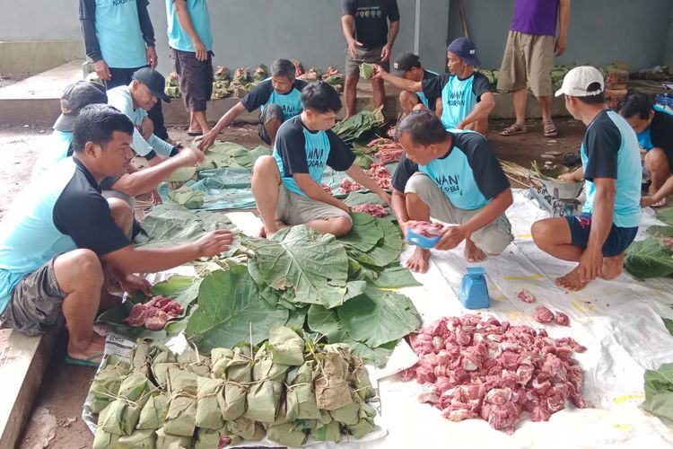 Panitia membungkus daging kurban menggunakan daun jati di Mushala Mutmainah, Desa Kracak, Kecamatan Ajibarang, Kabupaten Banyumas, Jawa Tengah, Kamis (29/6/2023).