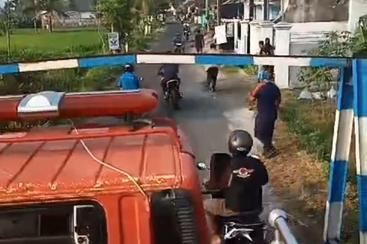 Tangkapan layar video mobil damkar terhalang portal jalan di Lumajang. Hal ini menghambat kinerja pemadam kebakaran karena petugas harus mencari pemegang kunci portal sehingga mereka bisa menuju lokasi kebakaran.
