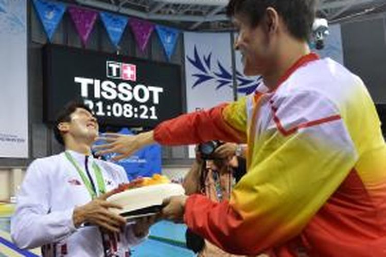 Atlet renang China, Sun Yang (kanan) bercanda dengan atlet renang Korea Selatan, Park Tae-hwan, Jumat (26/9/2014). Setelah bertanding di kolam renang mewakili negara masing-masing, Sun memberikan kejutan untuk Park, dengan membawakan kue ulang tahun setelah seremoni penyerahan medali. Park berulang tahun ke-25 pada Sabtu (27/9/2014). 