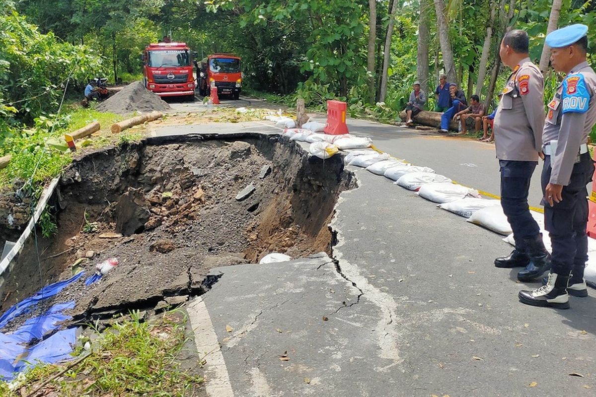 Bahu ruas jalan Sentolo - Nanggulan menganga karena tanah longsor di padukuhan Setan, kalurahan Wijimulyo, kapanewon Nanggulan, kabupaten Kulon Progo, Daerah Istimewa Yogyakarta. Aspal ikut terbawa longsoran tanah.