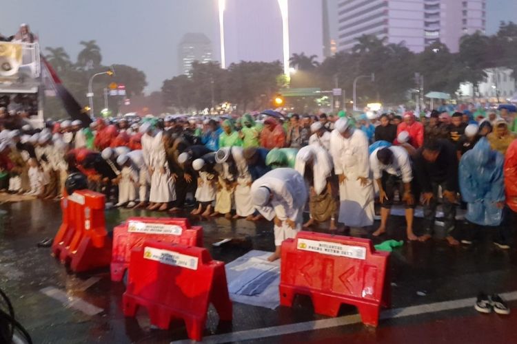 Massa aksi dari organisasi masyarakat (ormas) Islam yang mengatasnamakan Gerakan Nasional Pembela Rakyat (GNPR) melaksanakan shalat magrib berjamaah di tengah demo 411 di Patung Kuda, Jakarta Pusat, Jumat (4/11/2022) sore.