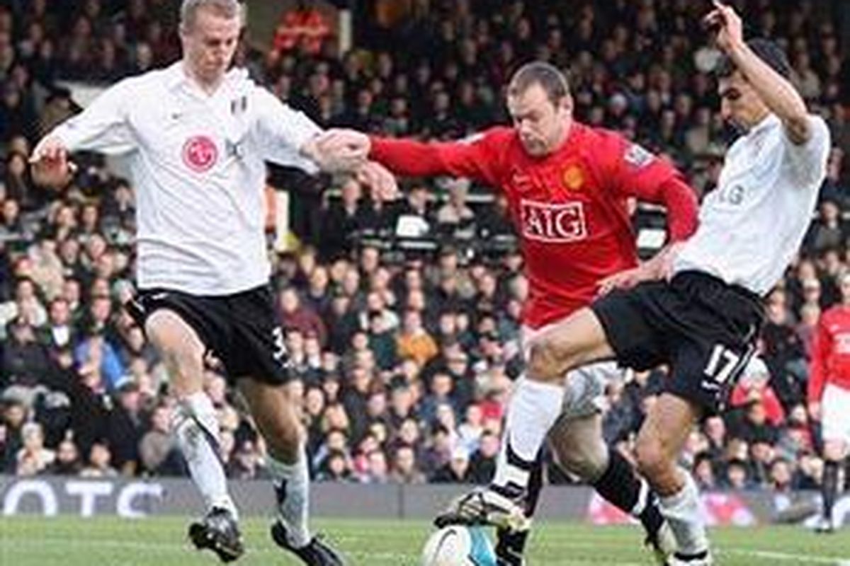 Wayne Rooney (tengah) saat berlaga di kandang Fulham, musim lalu. Striker Manchester United itu kemungkinan hanya menjadi pemain cadangan dalam duel Rabu (18/2).